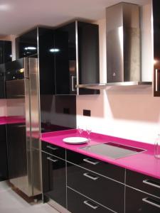 萨拉曼卡Albergue Revolutum Hostel的厨房配有粉色台面和黑色橱柜