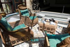 奥朗日尚布尔 d'HôtesJustin de Provence酒店的庭院设有藤椅和带茶壶的桌子。