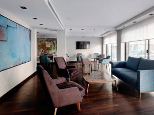 巴塞罗那巴塞罗那HG城市套房酒店的客厅配有沙发、椅子和桌子