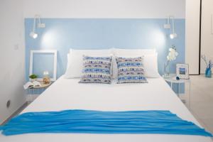 托雷斯港Il Pescatore di Sogni的一张白色的大床,配有蓝色和白色的枕头
