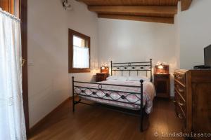 LastebasseIl Capriolo Felice - Agriturismo的一间卧室配有一张床、一个梳妆台和一扇窗户。