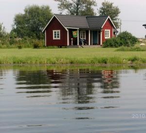 雪平斯维克Svalsjöns Stugor Öland的水边的红色房子