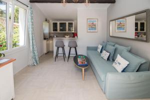 圣特罗佩Charmante petite maison a l'éntrée de Saint Tropez的客厅配有蓝色的沙发和桌子