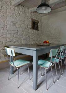 库蒂利亚诺SASSO AL MELO - Apartments的一张桌子,有四把椅子和一碗水果