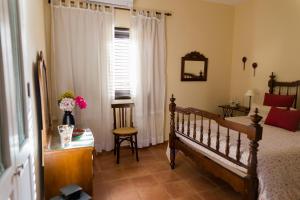 圣地亚哥海滩Los Olivos的一间卧室配有一张床、一张书桌和一个窗户。