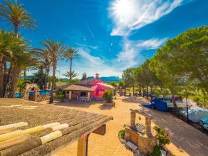 波连斯萨Can Cap de Bou by Alquilair的棕榈树和粉红色建筑的度假村