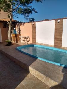 大伊瓜巴Casa com piscina e churrasqueira的一个带桌椅的庭院内的游泳池