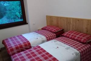 巴塞尔加·迪·皮纳Casa vacanze Insieme的两张睡床彼此相邻,位于一个房间里