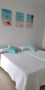 宏达瑞比亚ITXASO的卧室配有一张白色床,墙上挂有两张照片