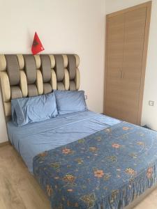 西迪布克纳德尔Presigia plage des nation Vacation Home的一间卧室配有一张带蓝色棉被的床