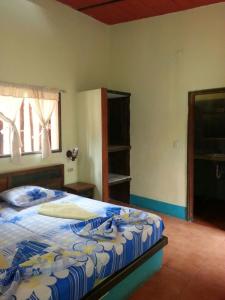 Puerto ColombiaHostal Nova Colonial的一间卧室配有一张带蓝色和白色棉被的床