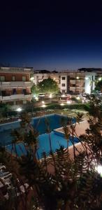 丰达切洛Taormina Mare Piscina Fondachello的一座夜间游泳池,其建筑背景为: