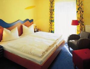 舍纳贝克浴疗公园酒店的一间卧室配有一张床和一把椅子