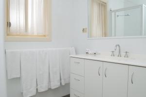 Barooga运动家汽车旅馆的白色的浴室设有白色毛巾和水槽