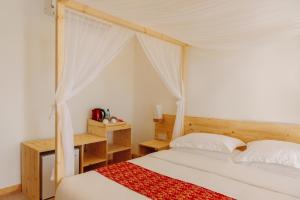 Maradhoofeydhoo马尔代夫海浪之声3S旅馆的一间卧室配有一张带天蓬的床