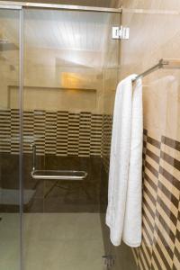 亭可马里MRD Beach Hotel的浴室设有2条悬挂在淋浴上的白色毛巾