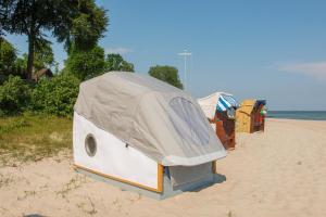 希尔克道夫Schlafstrandkorb Nr.2的海滩上的露营车,上面有帐篷