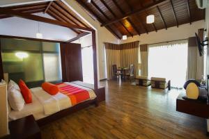 帕西库达平静度假村的一间卧室配有一张带橙色枕头的大床