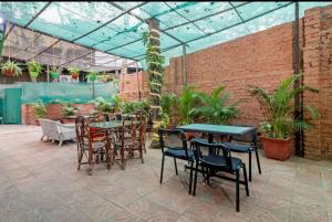 孟买Hotel Arma Residency的温室里带桌椅的庭院
