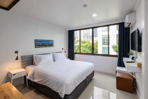 曼谷Every Surawong的一间卧室设有一张床和一个大窗户