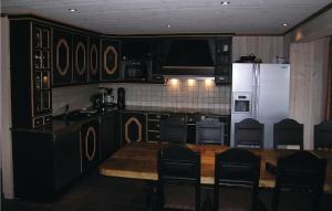 海姆瑟达尔Cozy Home In Hemsedal With Wifi的厨房配有桌子和白色冰箱。