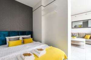 华沙Gama的卧室配有黄色和白色的床和沙发