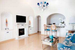 波西塔诺博埃梅专属豪华套房别墅酒店的客厅设有壁炉和电视。