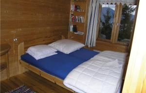 巴里斯川3 Bedroom Amazing Home In Balestrand的木制客房内的一张带两个枕头的床