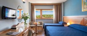 蒂勒尼亚欧陆大酒店的酒店客房带蓝色的床和镜子
