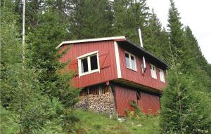 巴里斯川3 Bedroom Amazing Home In Balestrand的一座红房子,位于一座树木繁茂的山顶上