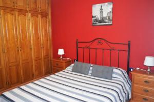 TriquivijateCasa de Campo Hiurma的一间卧室设有一张床和红色的墙壁