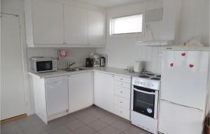 格尔斯维克Strandstua的厨房配有白色橱柜和白色冰箱。