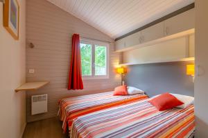洛特河畔卡斯泰尔莫龙Lagrange Grand Bleu Vacances – Résidence Port Lalande的一间卧室设有一张床和一个窗口