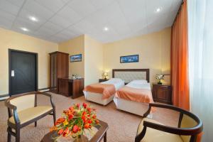沃罗涅什沃罗涅日酒店的酒店客房带两张床和一张桌子以及椅子。