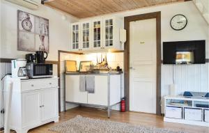 斯特兰奈斯Lovely Home In Strngns With Kitchen的厨房配有白色橱柜和墙上的时钟