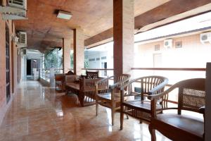 肯达利RedDoorz Plus at Hotel Srikandi Kendari的用餐室配有木桌和椅子