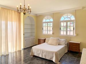阿尔姆尼卡CHALET CON PISCINAS Y VISTAS DE ENSUEÑO的一间卧室设有一张床和两个窗户。