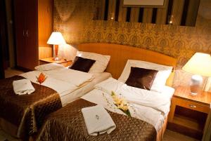 乔左维尔考普尔斯基MCM普拉斯酒店的两张位于酒店客房的床,配有毛巾