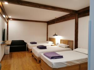 北京北京东堂轻奢酒店的一间设有三张床和椅子的房间
