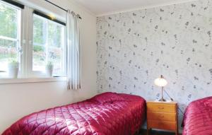 韦特兰达2 Bedroom Cozy Home In Vetlanda的一间卧室设有红色的床和窗户。
