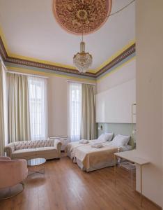 希俄斯Agora Residence的一间卧室配有一张床、一张沙发和一个吊灯。