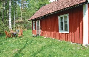 ForsvikKvighult的前面设有一张桌子和椅子的红色小屋