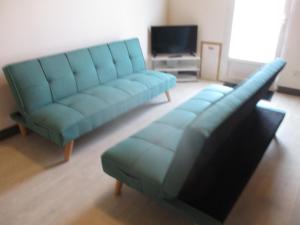 卡斯提永拉巴泰伊L'Escale的客厅配有蓝色的沙发和电视