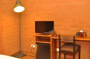 达喀尔Hotel Le Djoloff的客房设有书桌、电视和椅子