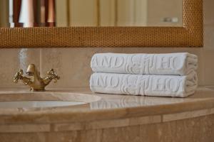 克拉科夫格兰德酒店的水槽旁的浴室台上堆着毛巾