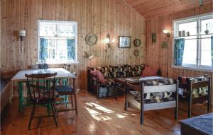 SannidalPet Friendly Home In Sannidal With Kitchenette的木墙和桌椅的房间