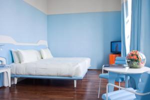 巴里JR Hotels Bari Grande Albergo delle Nazioni的蓝色卧室配有床、桌子和椅子