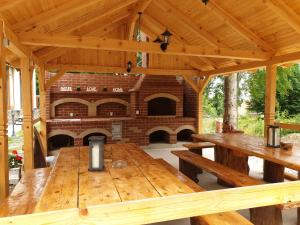 DrăguşCasuta Din Padure的木制凉亭配有大型木桌和 砖炉