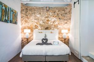 威廉斯塔德Sirena Bay Estate的卧室配有带两盏灯的白色床
