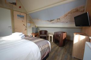 霍勒姆阿默兰岛比吉恒酒店的配有一张床和一台平面电视的酒店客房